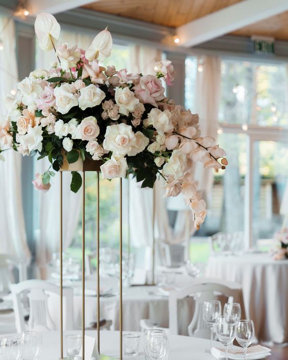 a refined tall wedding centerpiece of white and blush roses, white anthuriums and orchids is adorable and chic