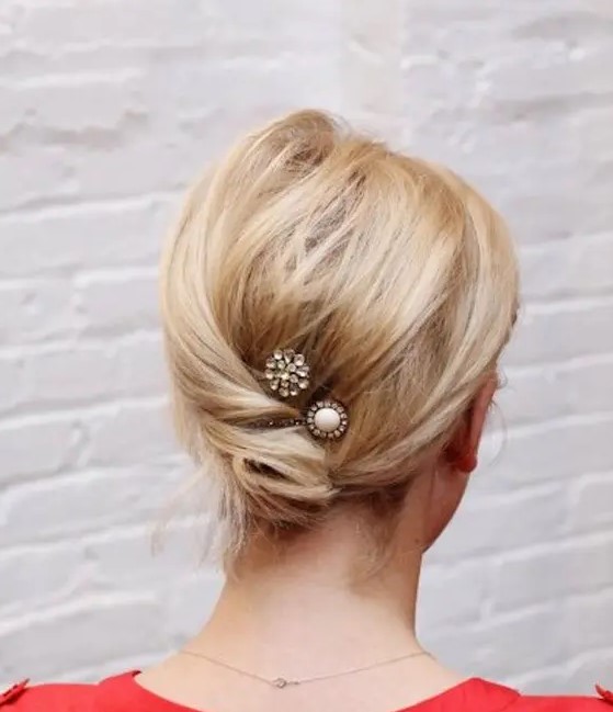 a simple twisted low updo with a messy top and a couple of rhinestone hair pins is idea for medium length hair