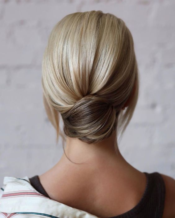 a sleek low chignon with a volume on top and some hair down is a cool idea for a modern wedding guest look