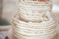 a stylish neutral ruffle wedding cake topped with neutral sugar blooms is a chic and catchy idea for a modern wedding