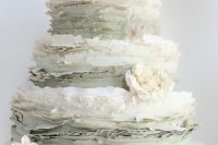 a subtle white and pale green ruffle wedding cake topped with neutral blooms for a spring or summer wedding