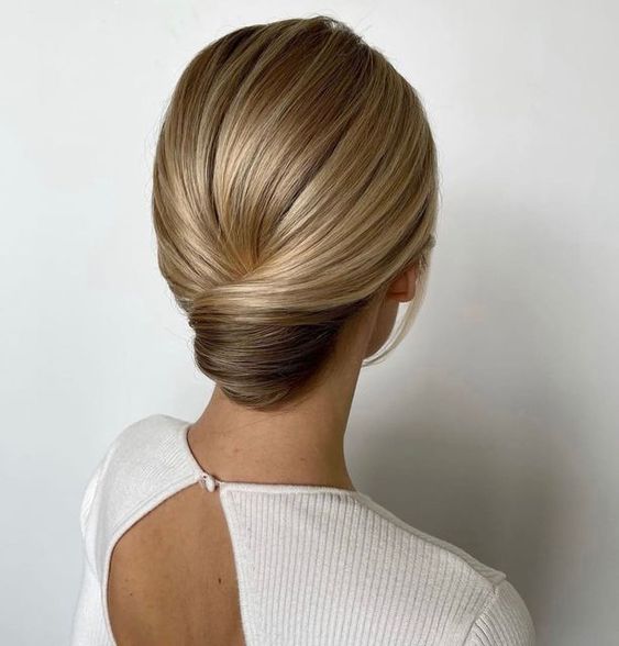 A super sleek and elegant low chignon with a sleek top is a stylish idea for a formal wedding, it will be picture perfect