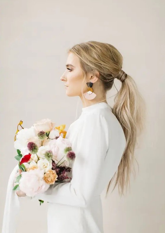 a usual messy ponytail with a texture, a volume on top is ideal for a modern or minimalist wedding