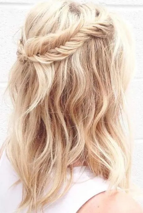 a wavy and textural half updo with a fishtail braid to frame it is a relaxed and cute option