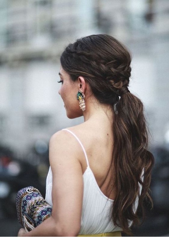 a wavy ponytail with a bump and a braided halo for a casual and modern bride