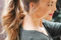 a wavy ponytail with a fishtail braid on one side and some bangs is a relaxed and casual wedding hairstyle idea