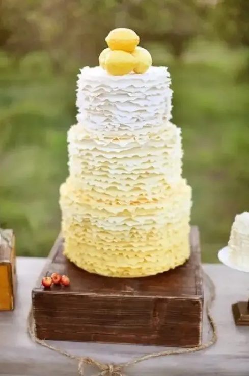 A whimsical and cute ombre ruffled wedding cake with lemons on top for a vintage inspired wedding