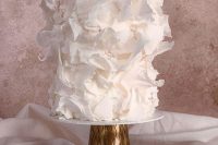 a whimsical ethereal white wedding cake all covered with ruffles looks absolutely adorable