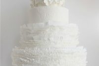 a white textural and ruffle wedding cake topped with white hydrangeas is a cool and chic idea