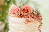 a white tiered wedding cake with copper edges, pink and white blooms, greenery and berries is amazing for spring or summer
