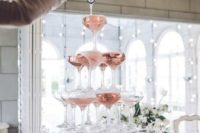 an elegant champagne tower with pink champagne is an amazing glam and sparkling idea