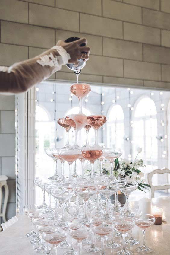 an elegant champagne tower with pink champagne is an amazing glam and sparkling idea