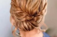 an elegant low updo with a braided halo and a low bun plus some volume on top is a cool and chic idea