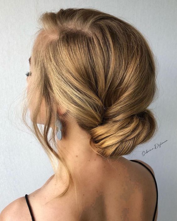 an elegant twisted low bun with hair framing the face and a bump is a chic and refined idea to rock