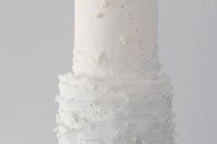an ombre white to light blue ruffle wedding cake with pearls, sugar blooms and some patterns is a very chic and ethereal idea