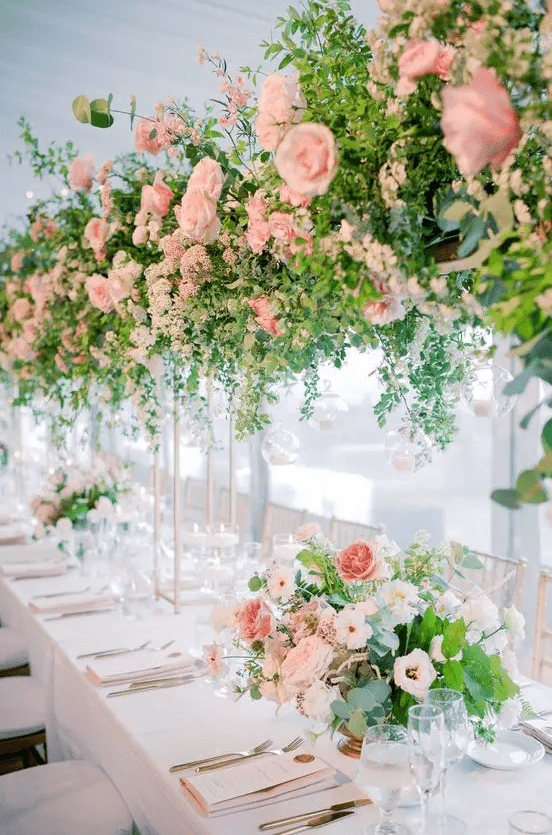 Refined wedding table decor with tall and large blush wedding centerpieces that are doubles in the on table floral arrangements