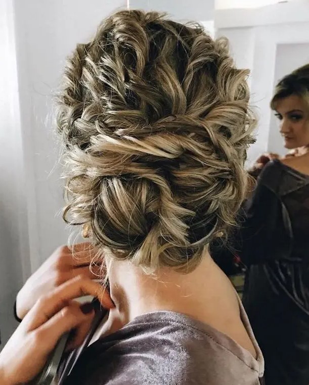 tie up your curly hair into a large twisted low bun, it will look very textural and messy, which is trendy