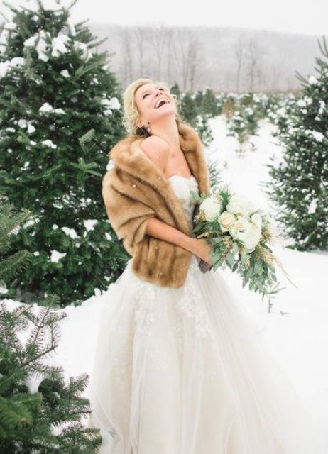 a chic beige faux fur stole contrasts the neutral wedding gown and makes the bride look chic and sophisticated