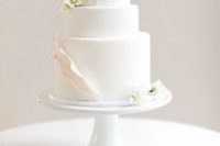 05 a chic white wedding cake with textural touches and gold edging plus fresh white flowers, modern classics
