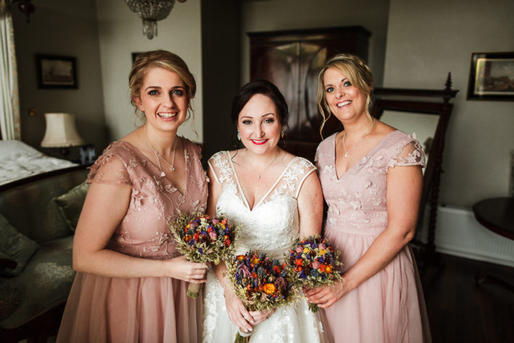 The bridesmaids were wearing dusty pink gowns with floral appliques