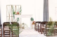 06 The ceremony space was styled with oversized tropical leaves and a faux mantel with lush tropical blooms