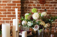 07 The wedding tablescape was done with an uncovered table, plum-colored napkins, large candles and lush florals