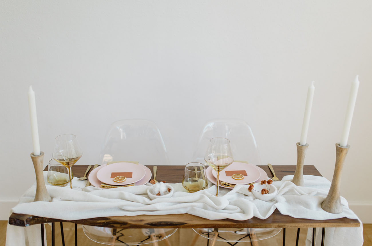 The sweetheart table was decorated with a fabric runner, wooden candle holdersm touches of gold and pink