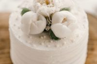 09 an elegant textural white wedding cake topped with white peonies and edible pearls will never go out of style