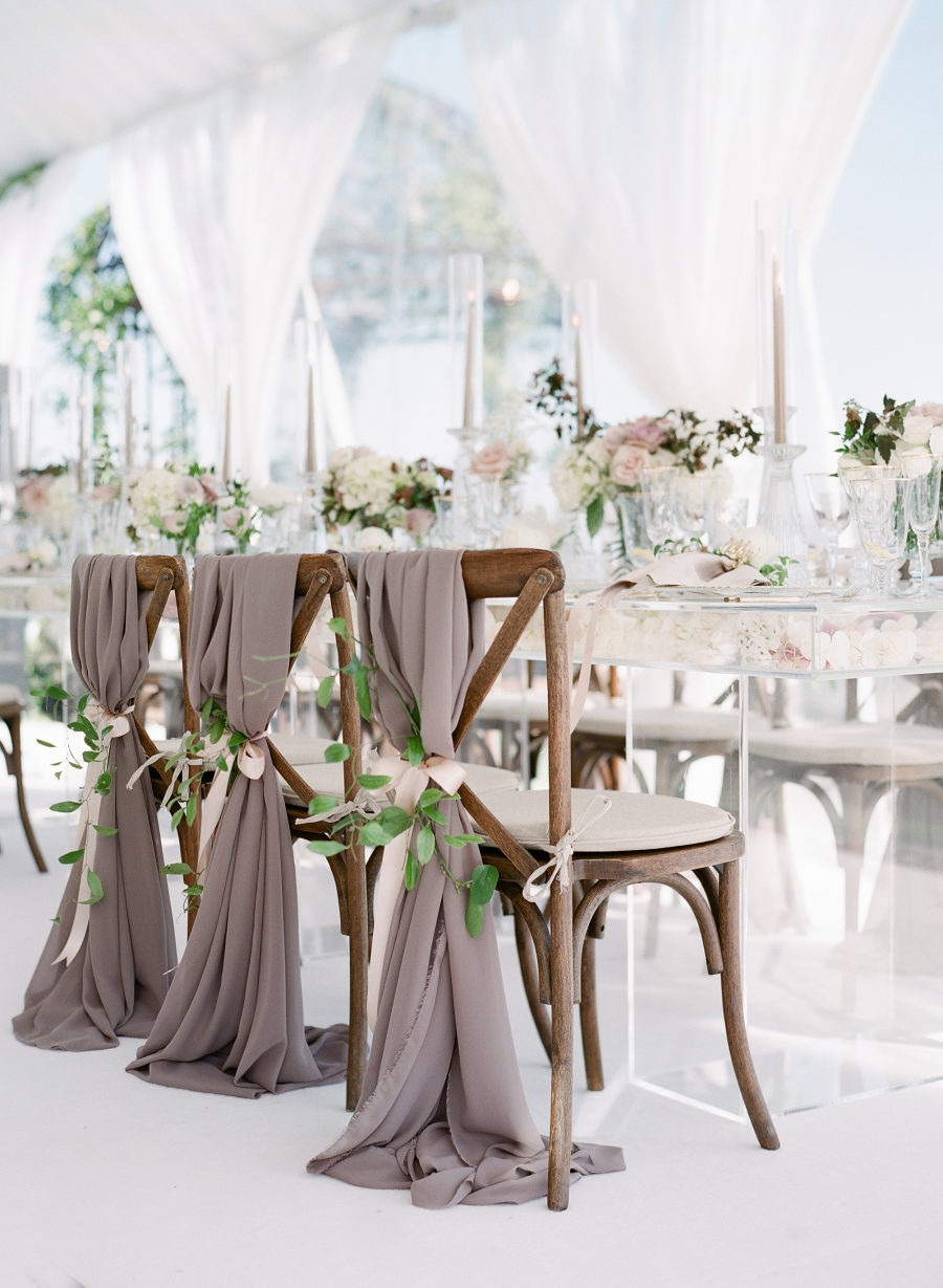The chairs were decorated with taupe hangers, foliage and blush ribbons for a sophisticated feel