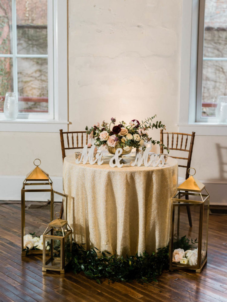 The sweetheart table was styled with greenery, blooms, lanterns and calligraphy