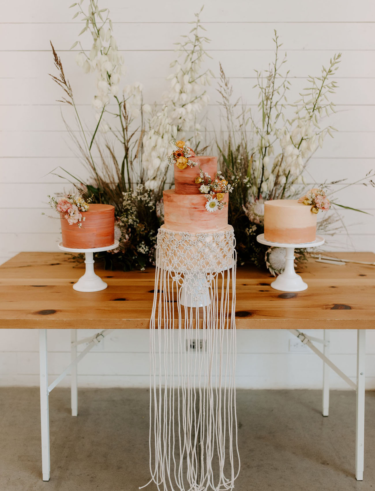 The wedding cakes were done in rust, with an ombre effect, blooms and macrame for decor