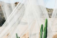 11 a desert ceremony space with potted cacti, sheer draping, and a bohemian accent rug make for one beautifully unexpected combo