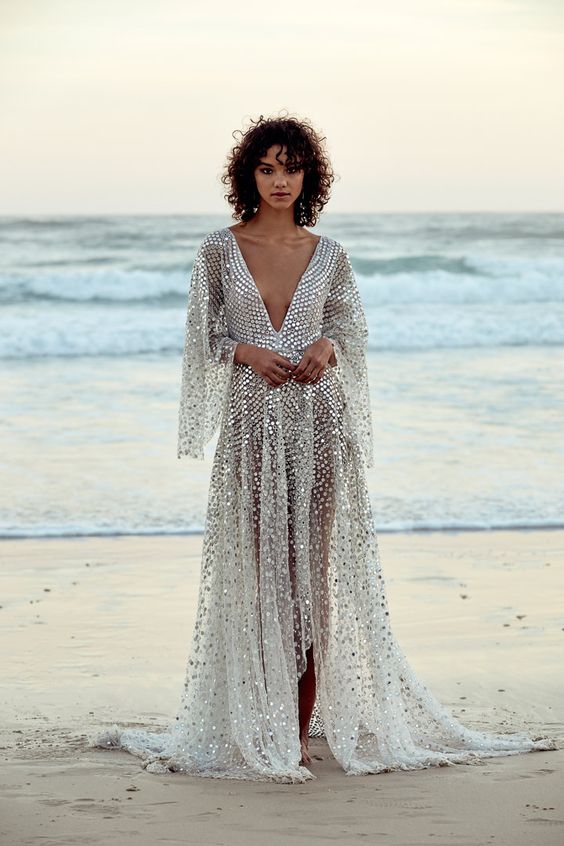 a stunning plunging neckline wedding dress with bell sleeves fully covered with silver sequins to imitate fish scales