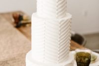 15 a white geometric wedding cake with a chevron pattern topped with an edible cactus is a bold idea for a desert wedding