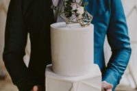 18 an all-white wedding cake with geometric 3D patterns and matching geometric toppers plus greeneery