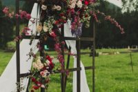 19 a forged frame decorated with airy fabric and lush colorful blooms plus a Persian rug for a dreamy outdoor ceremony
