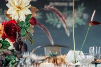 19 a luxurious decadent wedding tablescape with a faux fur table runner and dark blooms and herbs plus an uncovered wooden table