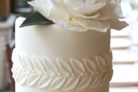 19 a white wedding cake with sugar leaves and a giant flower plus edible pearls is pure elegance with a modern twist