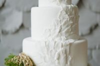 20 a plain white wedding cake decorated with sugar feathers is a unique idea for a boho chic wedding