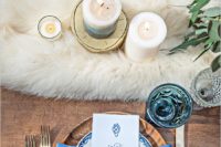 21 a white faux fur table runner, wooden chargers, blue glasses and napkins are great to make the tablescape chic and textural