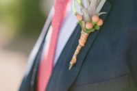 26 an air plant paired with hypercum berries that match the groom’s tie in color