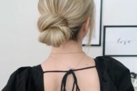 a beautiful and chunky twisted low bun on thick and long hair, with a sleek volume on top and face-framing locks