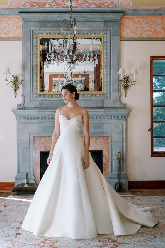a beautiful and elegant strapless wedding ballgown with a draped bow bodice, a plain and pleated skirt and a train for a formal wedding