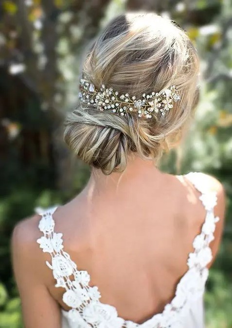 a beautiful low bun with twisted hair and a messy wavy top and a sparkling hair vine look great