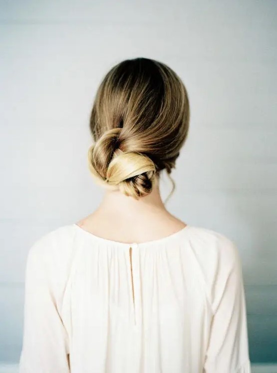 a beautiful twisted low bun with an ombre blonde touch is a chic idea for long hair, it can be rocked with many bridal styles