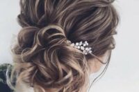 a beautiful wavy wedding updo with a wavy top and a low bun, a rhinestone hairpiece is a cool idea for long and medium hair