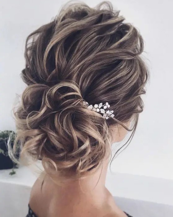 a beautiful wavy wedding updo with a wavy top and a low bun, a rhinestone hairpiece is a cool idea for long and medium hair