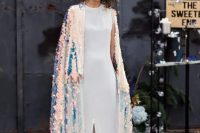 a bold modern bride wearing a minimalist white plain wedding dress with a slit and an iridescent sequin cove rup with a train
