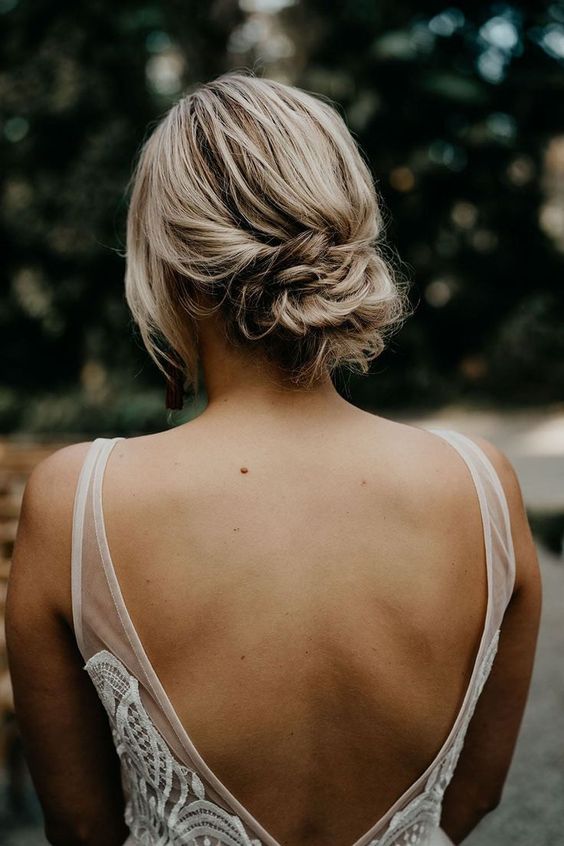 a chic and messy twisted low bun with a textured top and face-framing locks is a cool idea for a wedding, it's timeless classics