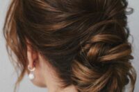 a chic low ballerina bun with a bump on top and face-framing locks is a cool idea for a wedding